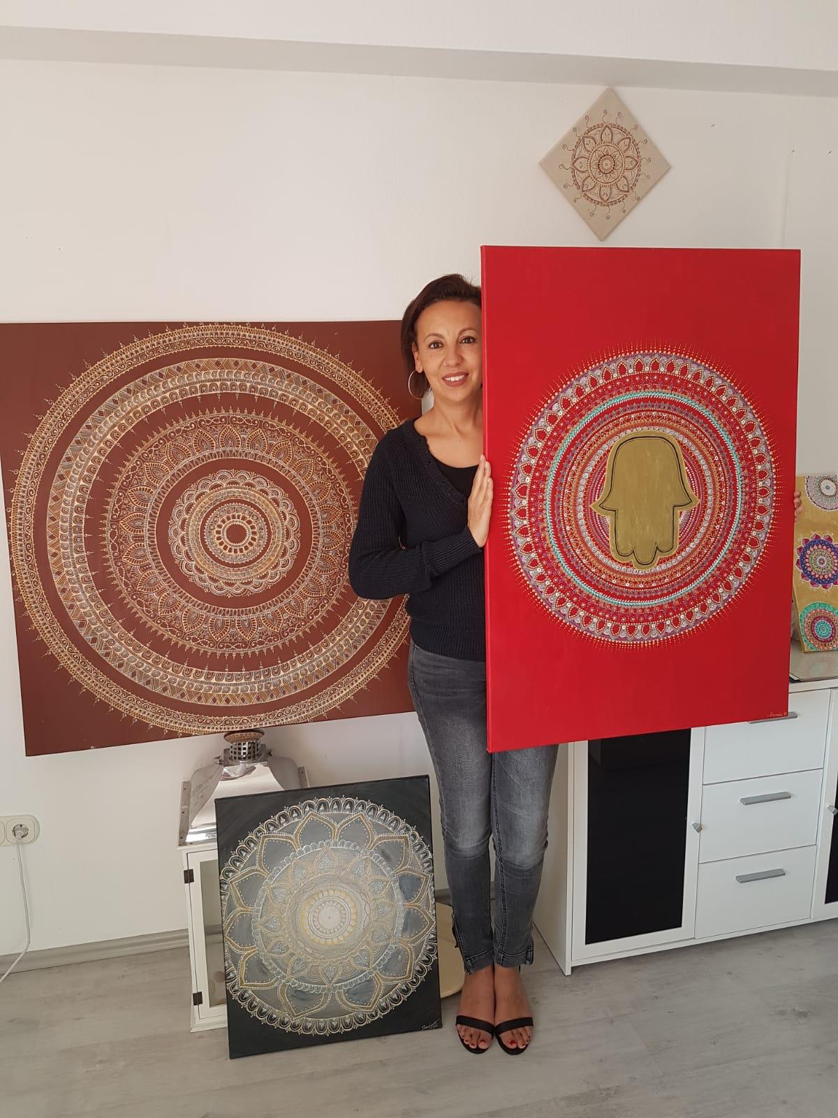 Frau zwischen mehreren großformatigen Mandala-Werken