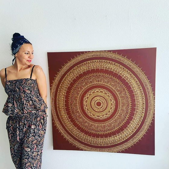 Soumia neben einem großformatigen Mandala